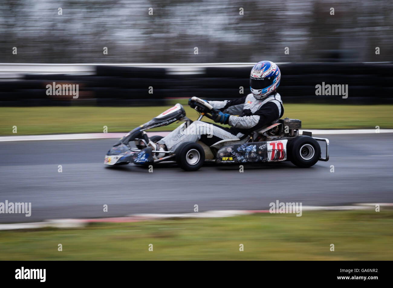 An image taken at slow shutter and panning of a speeding go kart traveling around a circuit. Stock Photo