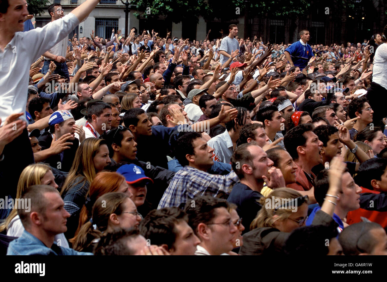 Crowd of fans gesture as they watch French national soccer team game on giant screen, Place de l'Hotel de Ville, Paris, France, June 2002. Stock Photo