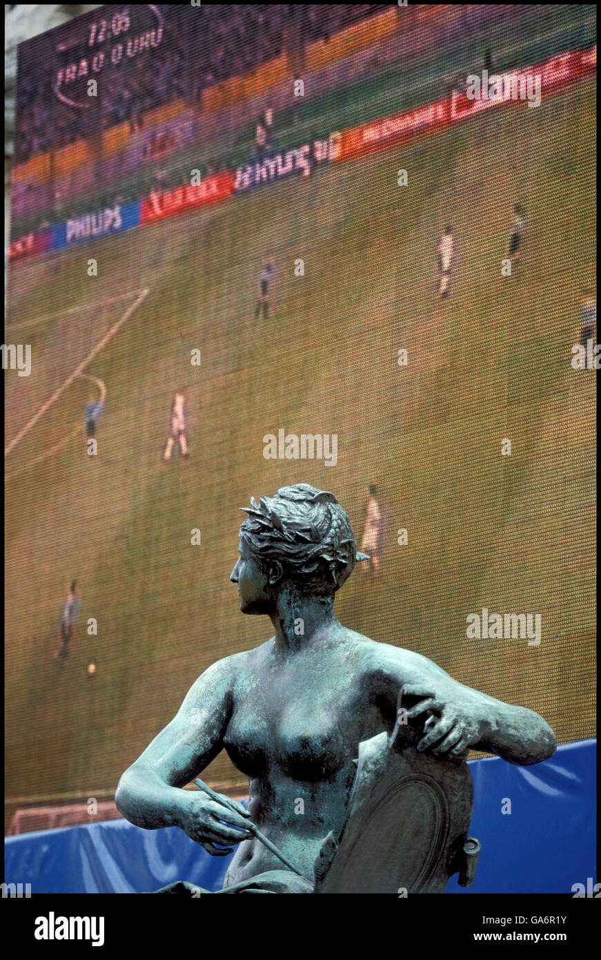 Statue at the Place de l'Hotel de Ville in Paris, France in front of giant screen showing a French national soccer team game, June 2002. Stock Photo