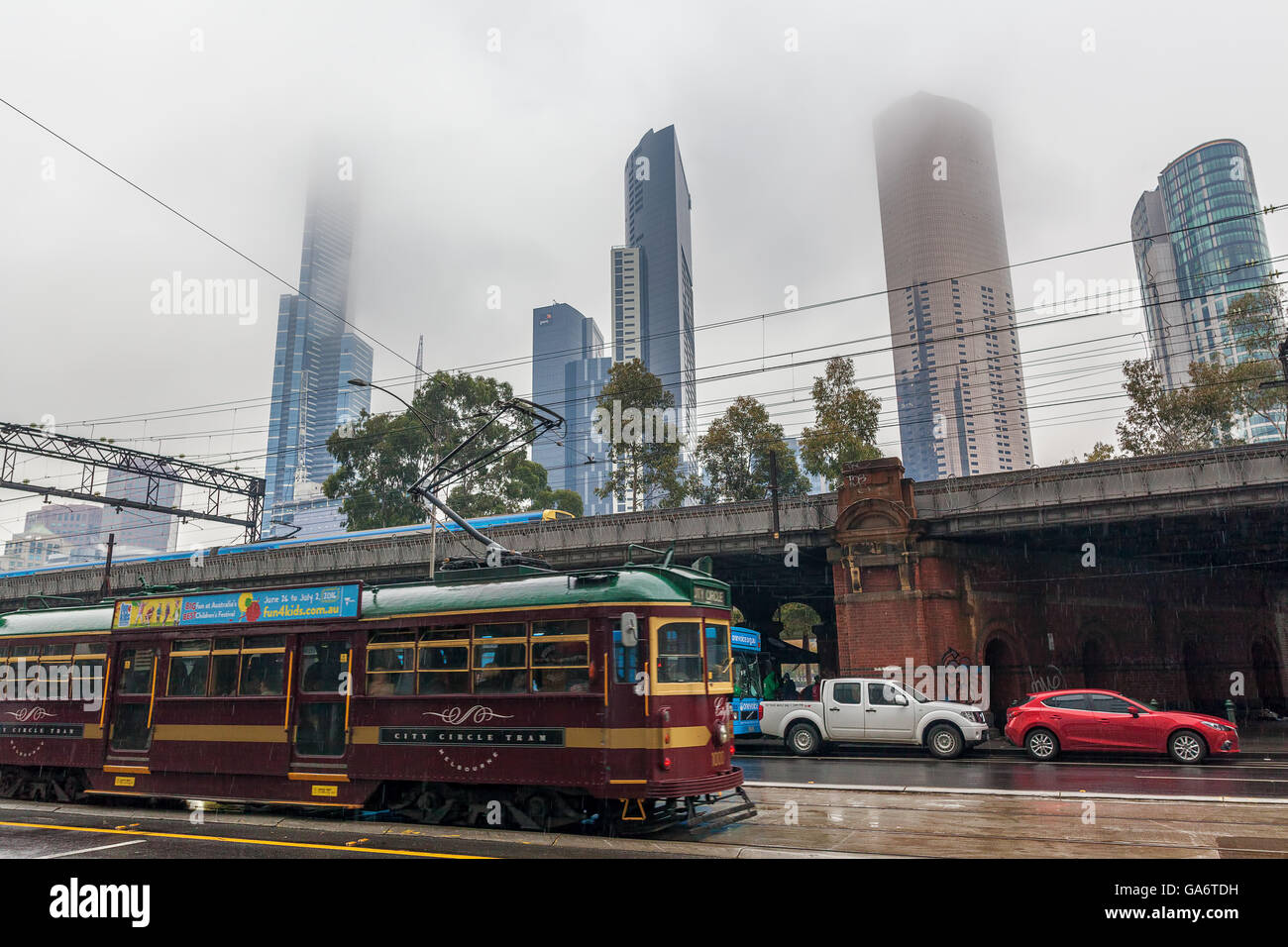 Melbourne CBD - Jun 4 2016: historical City Circle Tram and skyscrapers disappearing into the fog on cloudy rainy day. Stock Photo