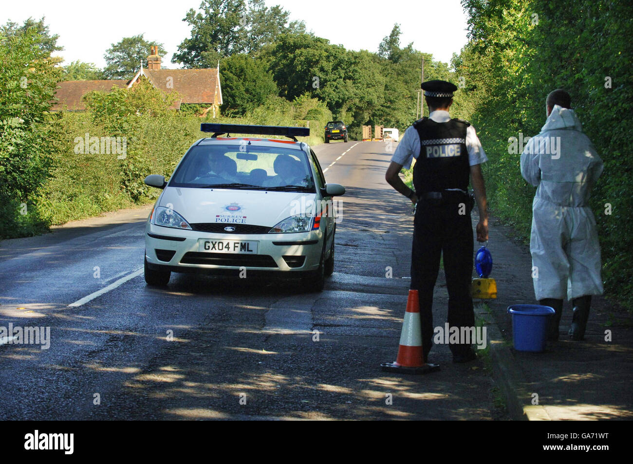 Police officers on Westwood Lane in Normandy, Surrey where a farm in