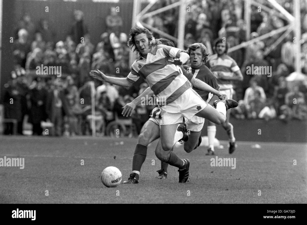 Queens Park Rangers' Stan Bowles is brought down from behind Stock Photo