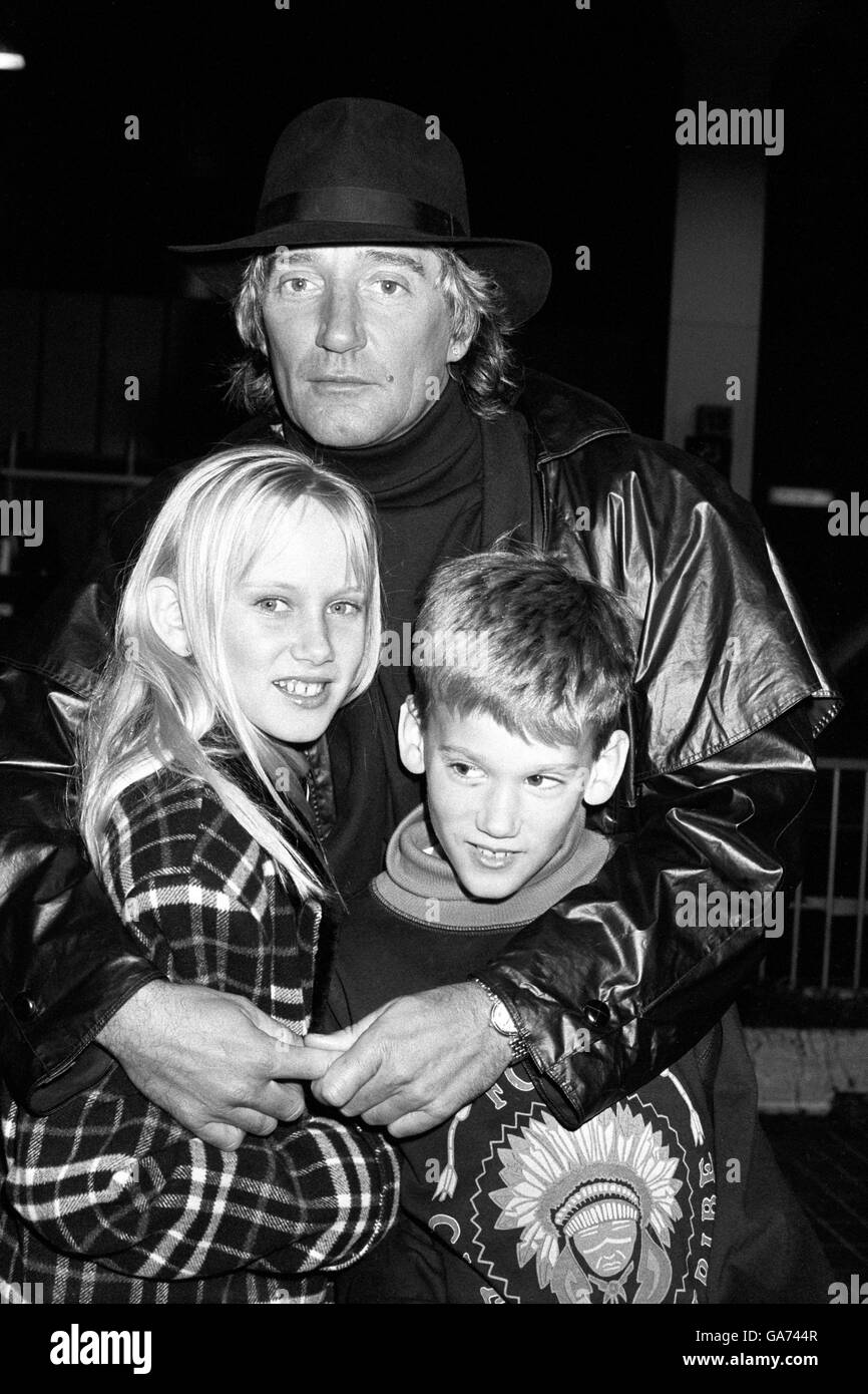 Rock star Rod Stewart embraces Kimberly, 10 and Sean, nine, children from his marriage to Alana Hamilton, at Heathrow Airport. Stock Photo