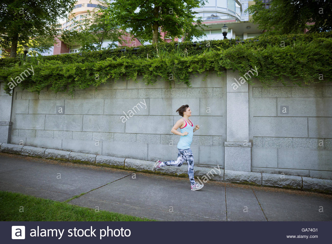 Woman running on suburban sidewalk Stock Photo - Alamy