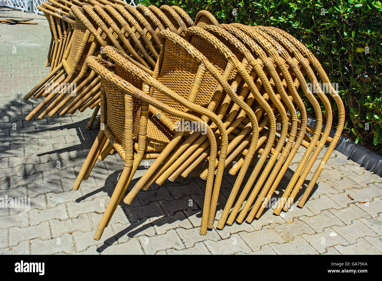 Plastic chairs stacked one on the other in the garden cafe. Stock Photo