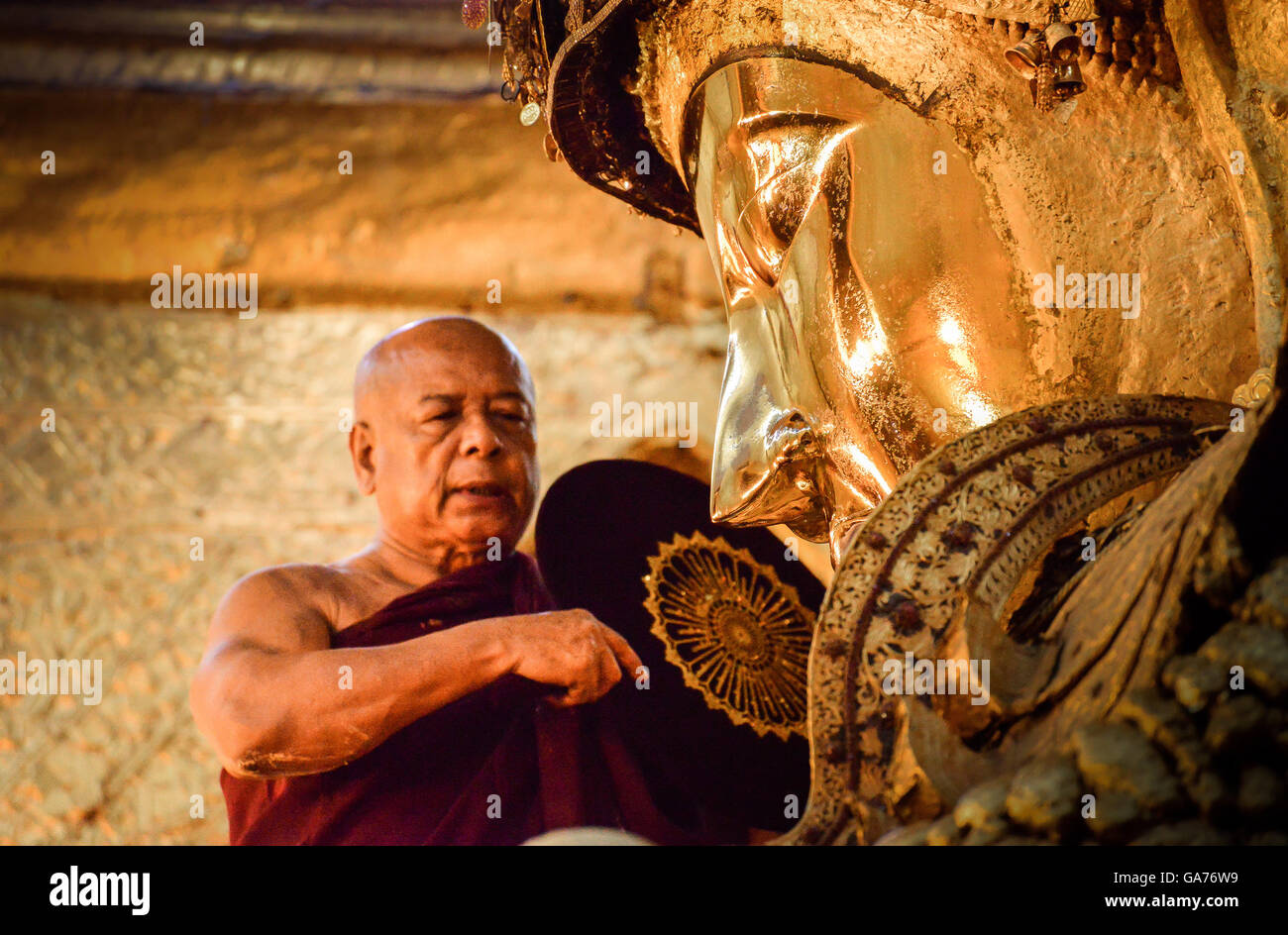 The head of monks performs a ritual, daily washing the face of Buddha Stock Photo