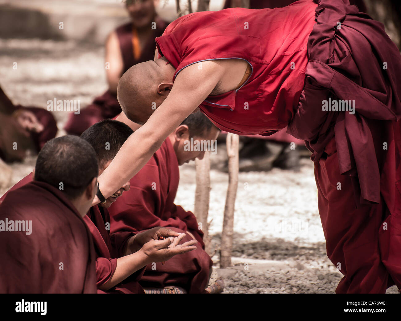 A senior monk challenges his fellow monks to debate Stock Photo