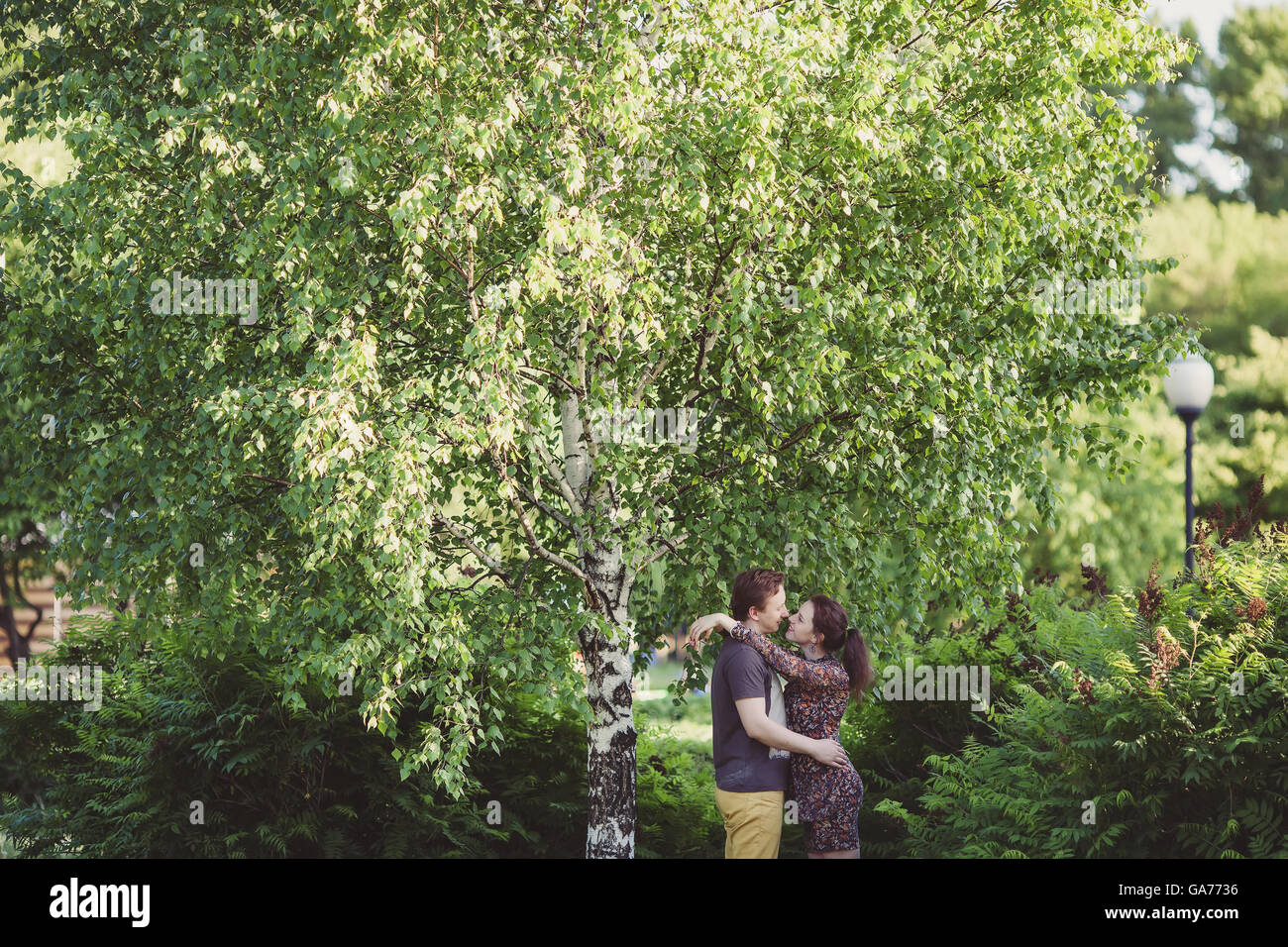 Happy couple in love walking in park, sunset Stock Photo - Alamy