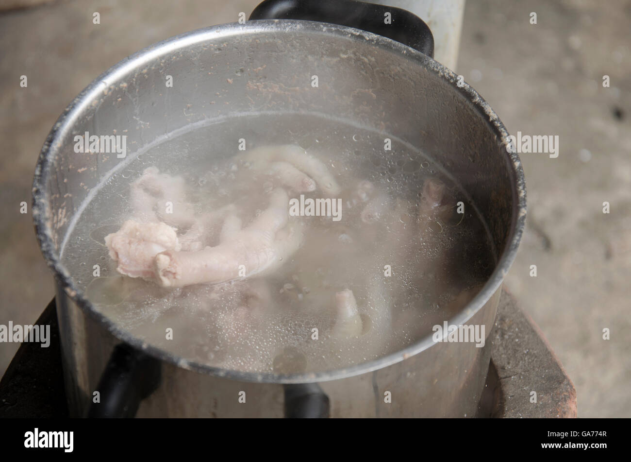 Boil chicken bone, foot and pork bone for cooking soup stock on Stove