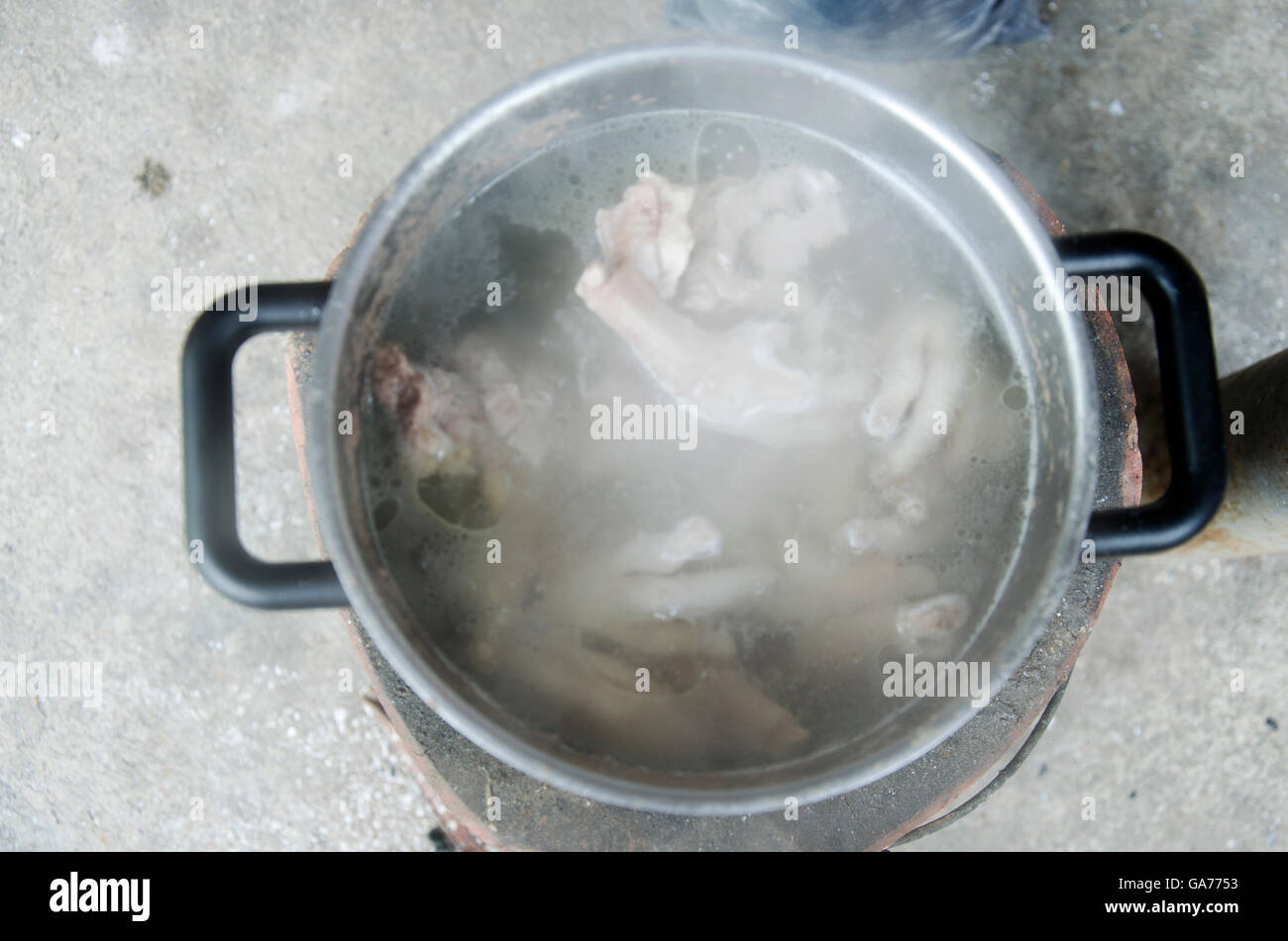 Boil chicken bone, foot and pork bone for cooking soup stock on Stove