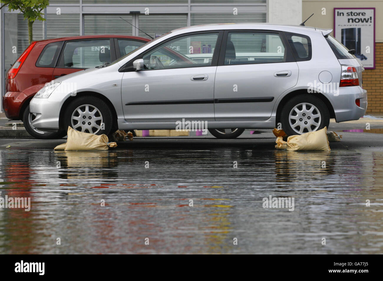 A stranded car on top of sandbags in the car park of PC World in Oxford