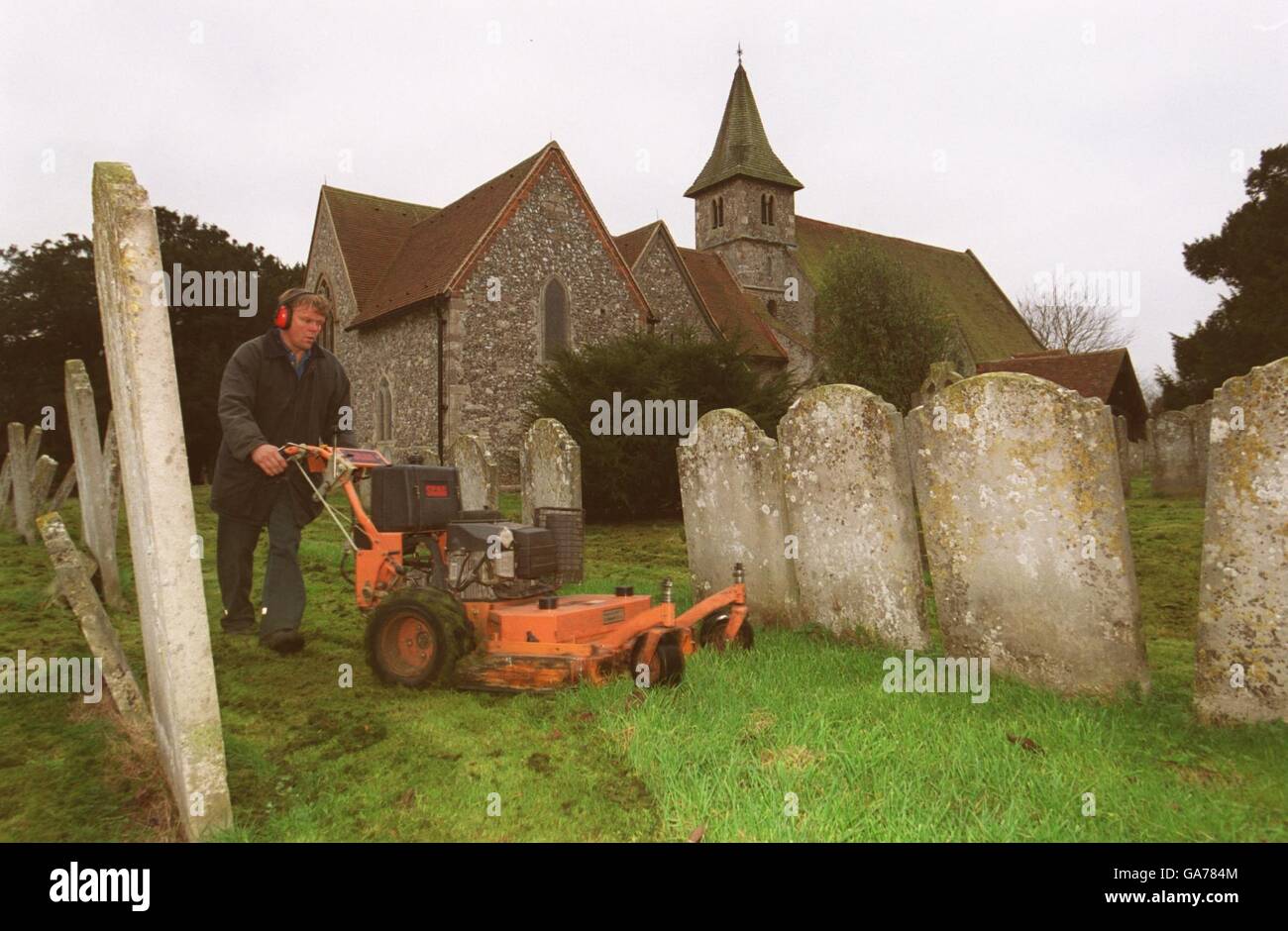 A worker keeps the grounds of the St Thomas a Becket church tidy Stock Photo