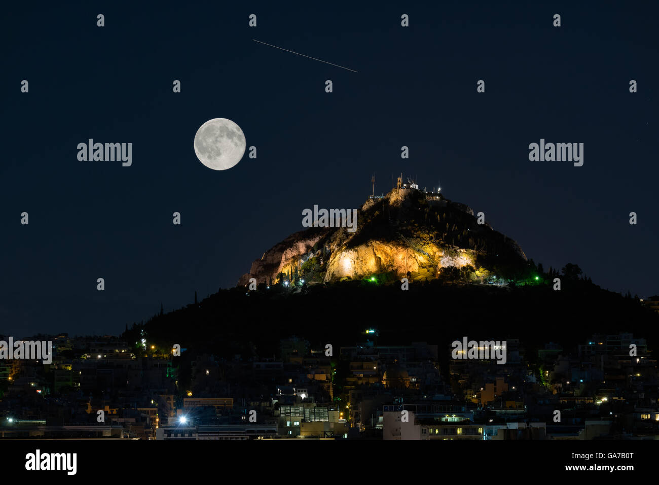 Lycabettus mountain in Athens Greece against the August full moon and a falling star. Stock Photo