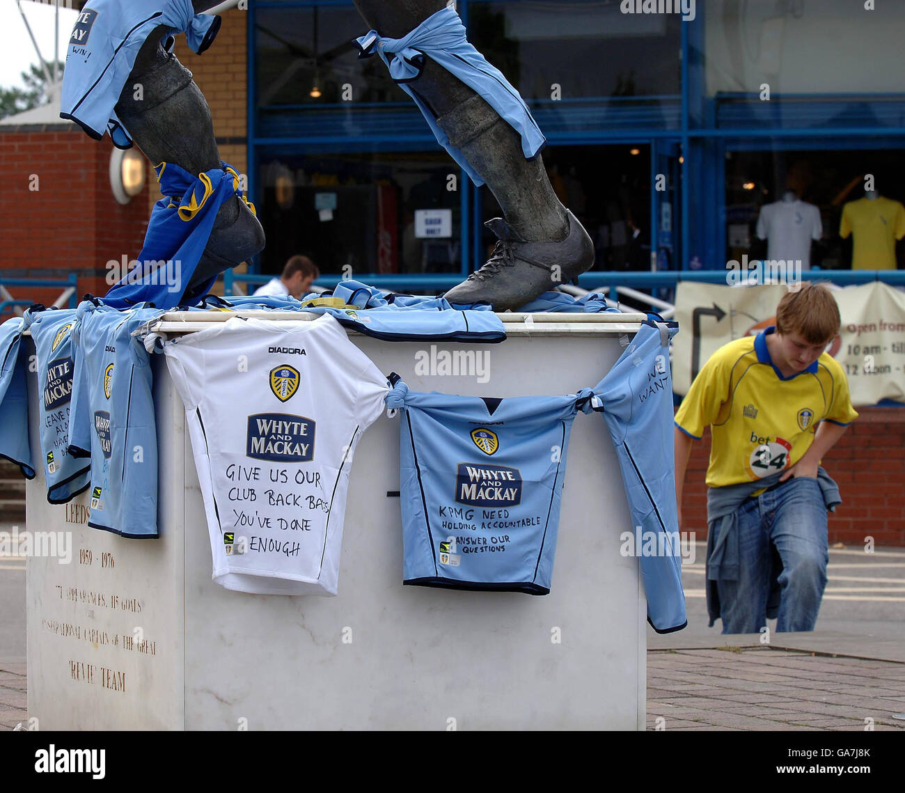Leeds United supporters place team shirts with messages around the statue of Billy Bremner at Elland Road, Leeds. Stock Photo