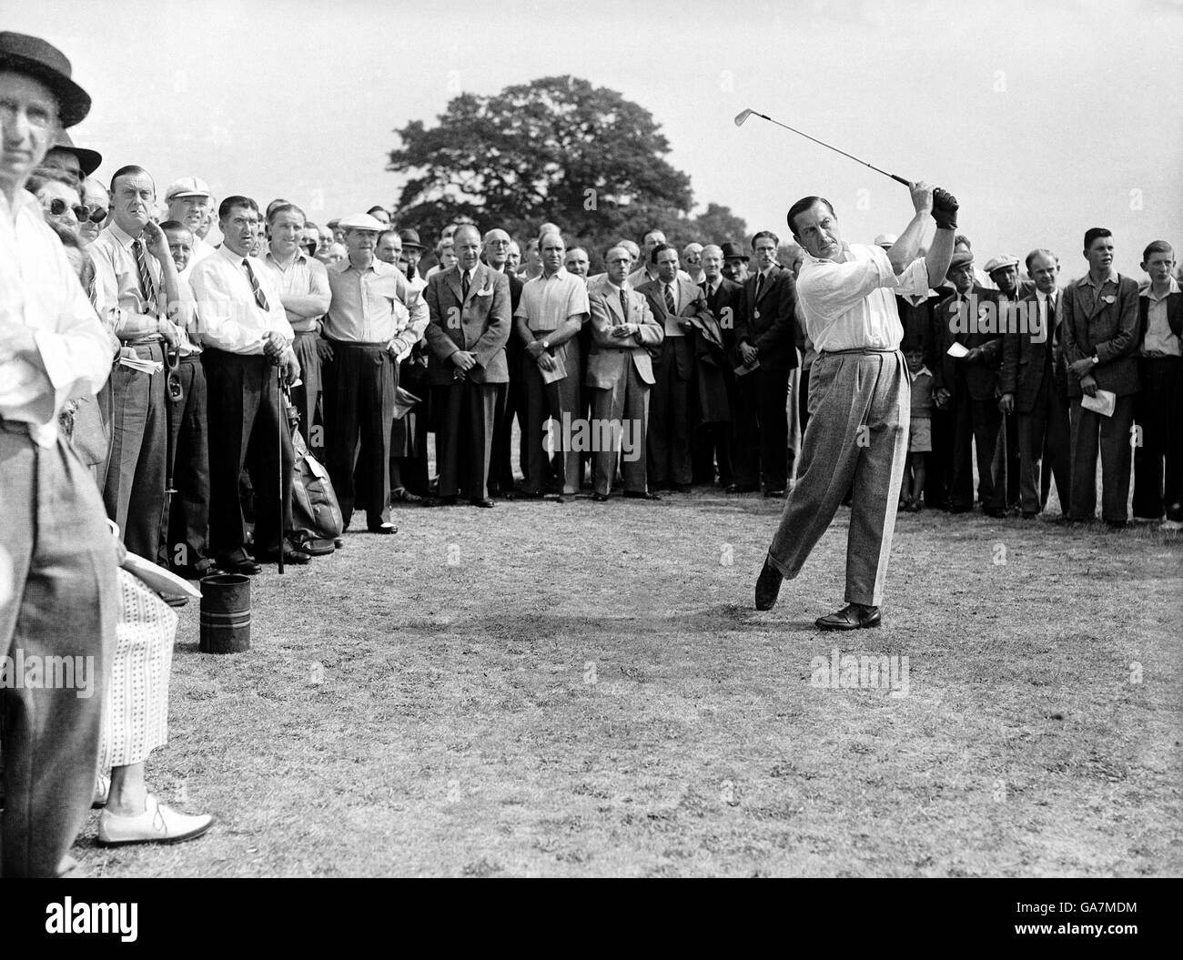 Golf - British Walker Cup Team v Professionals. Henry Cotton tees off, watched by a large gallery Stock Photo