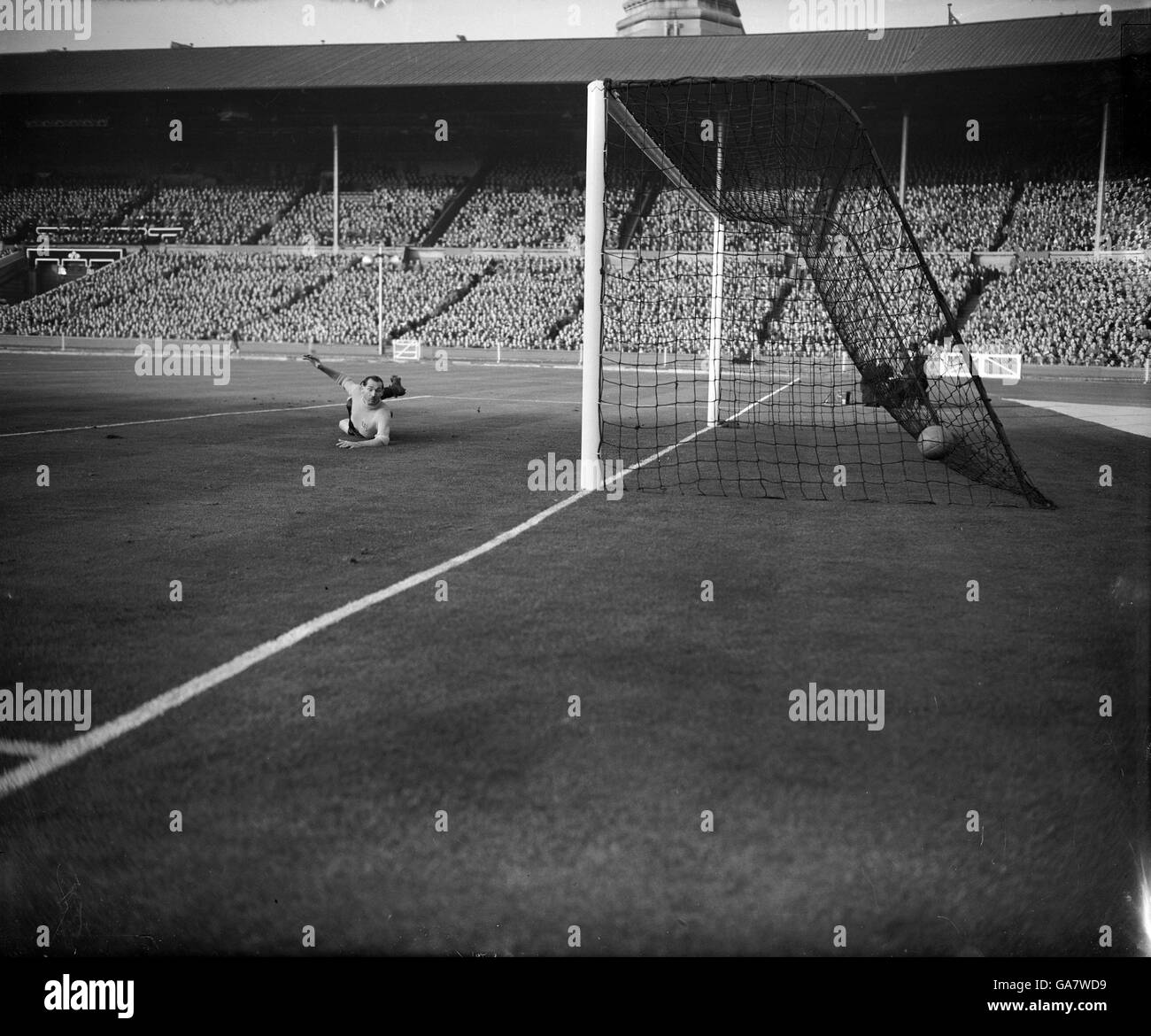 A full length dive by England goalkeeper Gil Merrick fails to save the