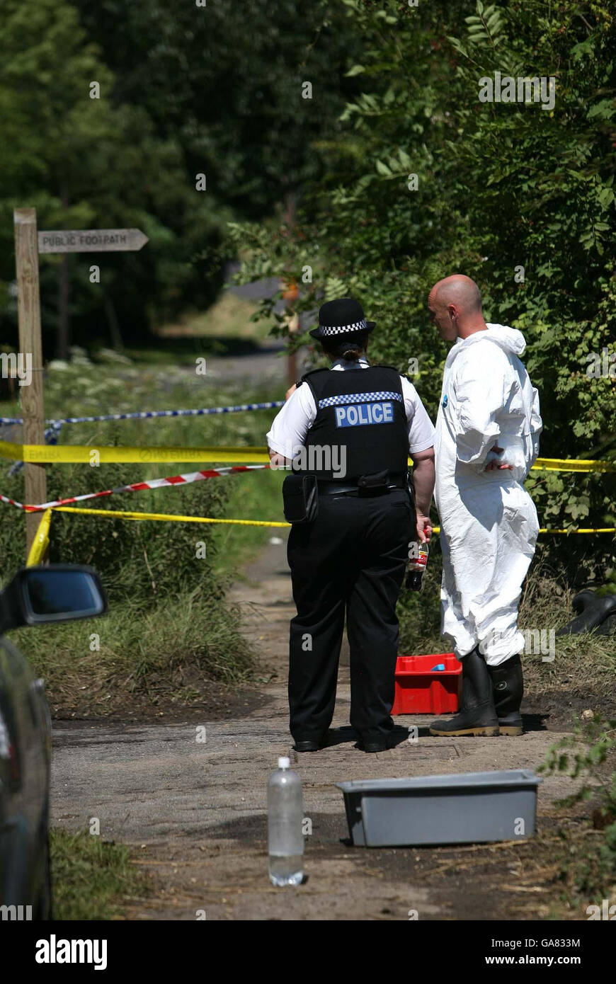 A member of the DEFRA response team and a police officer stand by a ...