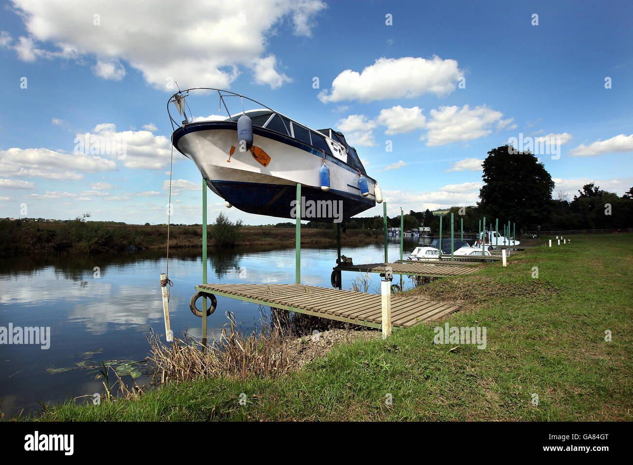 The cabin cruiser 'Vino Calypso', owned by Steve Blake and kept at Bredon on the Severn, near Tewkesbury, awaits rescue as it balances precariously on three wooden poles that have held it in place since the flood waters receded. Stock Photo