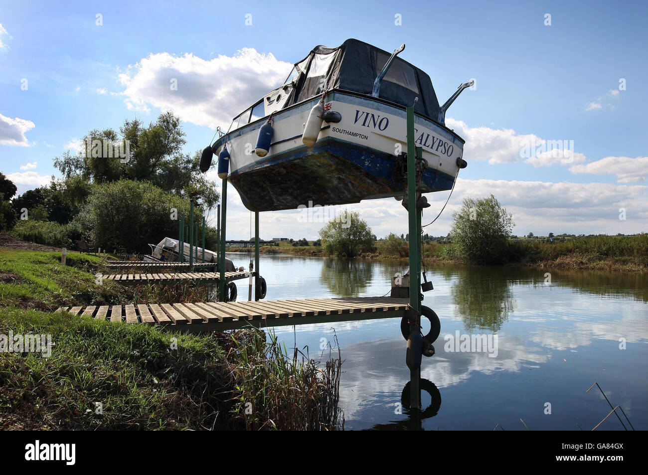 The cabin cruiser 'Vino Calypso' owned by Steve Blake and kept at Bredon on the Severn near Tewkesbury awaits rescue as it balances precariously on three wooden poles which have held it in place since the flood waters receded. Stock Photo