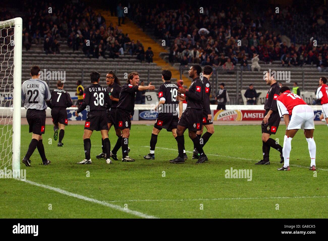 A dejected Thierry Henry of Arsenal puts his hands on his knees as Juventus players congratulate goalkeeper Fabian Carini after saving Henry's penalty Stock Photo
