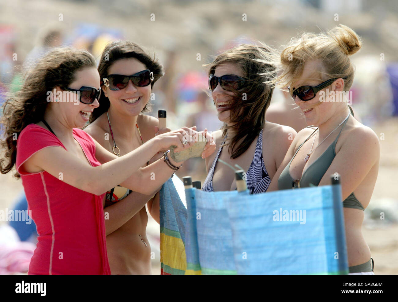 Holiday makers left to right: Sophie Morris, Charlotte Lewis, Ellie Houghton and Ester Jackson-Taylor enjoy the sun on Fistral Beach in Newquay. Stock Photo