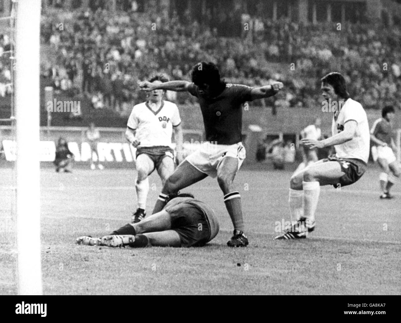 Chile's Elias Figueroa (c) shields his goalkeeper Leopoldo Vallejos (l) as East Germany's Jurgen Sparwasser (r) moves in to challenge Stock Photo