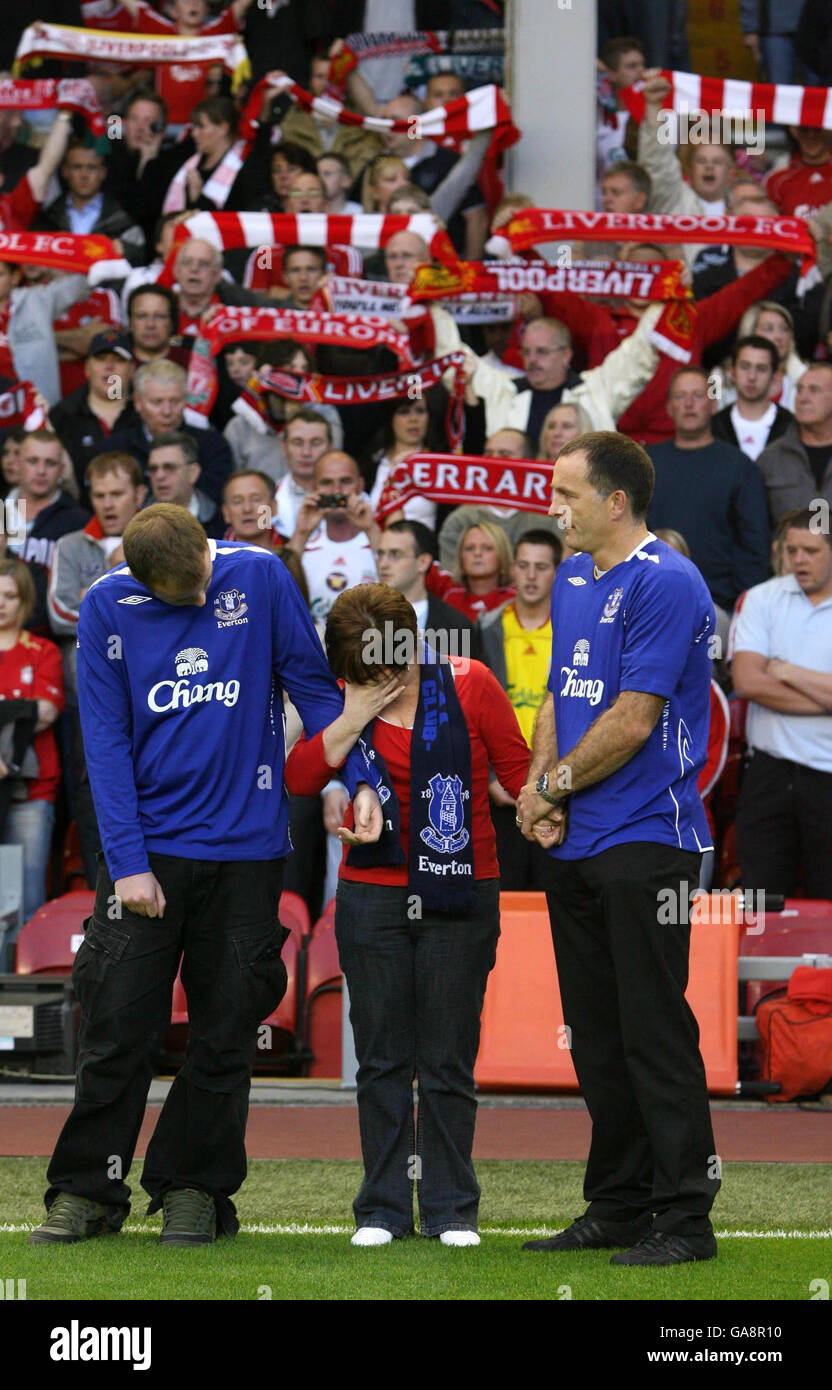 The parents of murdered schoolboy Rhys Jones, Melanie (centre) and Stephen Jones (right), stand with their elder son Owen (left) as the Everton football club anthem - Z Cars - is played before the Champions League Third Qualifying round second leg match at Anfield, Liverpool, between Liverpool and Toulouse. Stock Photo