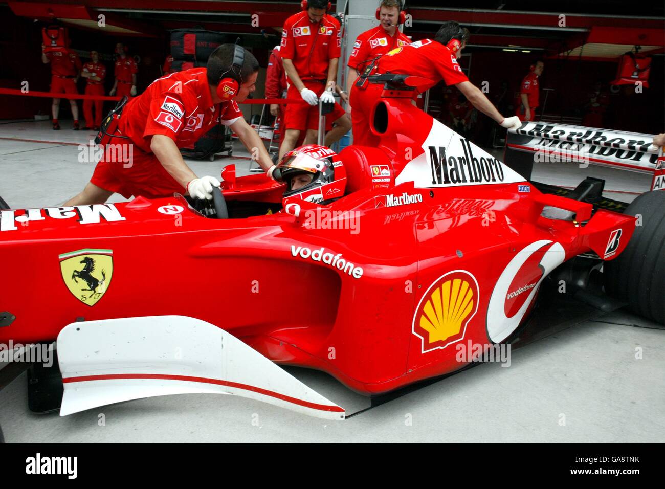 Ferrari's Michael Schumacher is steered back into the garage after the