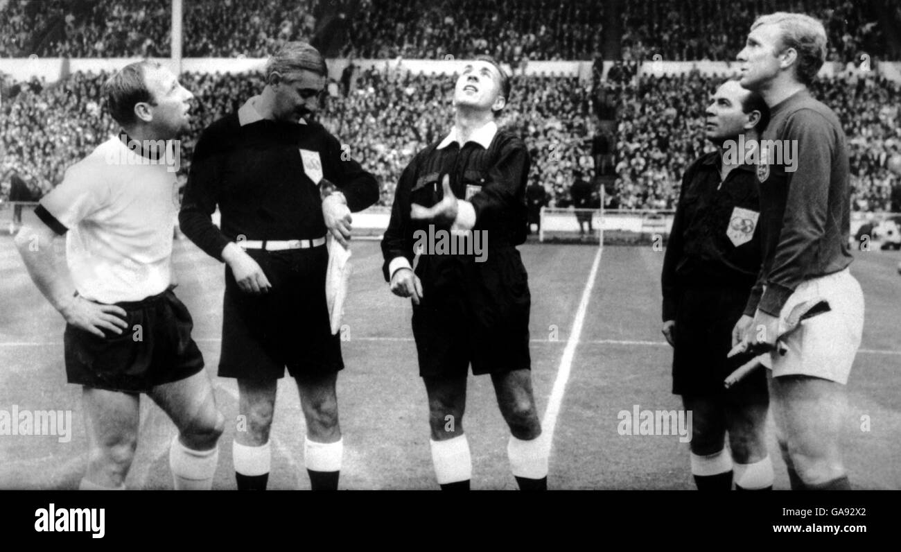 The two captains, West Germany's Uwe Seeler (l) and England's Bobby Moore (r), look on as referee Gottfried Dienst (c) tosses the coin before the match Stock Photo