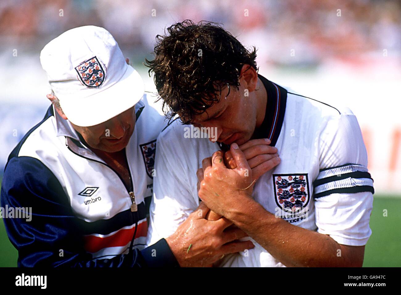 England's Bryan Robson (r) is helped off by the England doctor after dislocating his shoulder Stock Photo