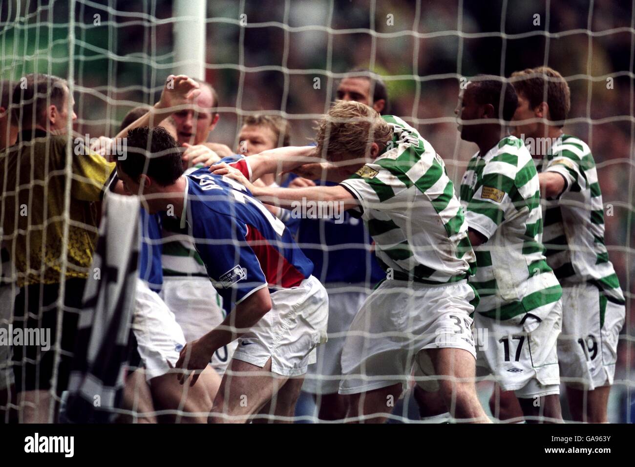 Scottish Soccer - Bank Of Scotland Premier League - Celtic v Rangers. Referee Kenny Clark seperates both sets of players as fighting breaks out Stock Photo