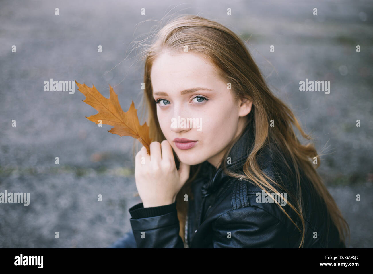 Portrait of a beautiful girl holding autumn leaf Stock Photo - Alamy