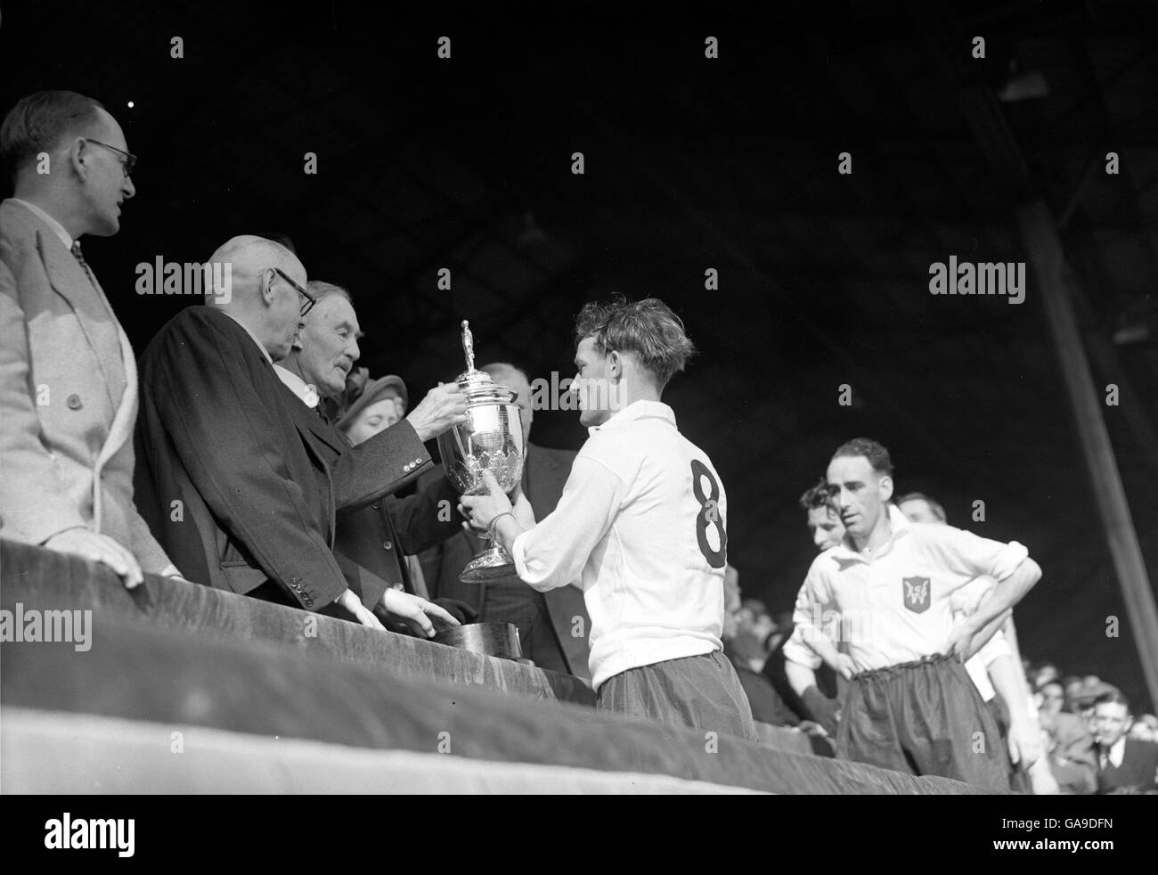 Eddie Taylor, Willington captain receives the trophy from Lord Wigram, Vice President of the FA, after he led his team to a 4-0 victory at Wembley. Taylor is a shipyard scaffolder by trade. Stock Photo