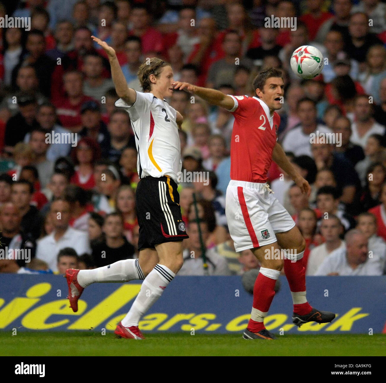 Wales' Samuel Ricketts in action with Germany's Marcell Jansen (left) during the UEFA European Championship Qualifying match at Millennium Stadium, Cardiff. Stock Photo