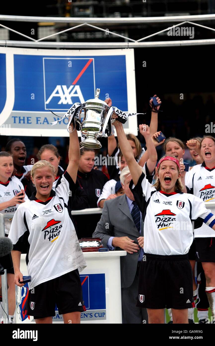 Fulham's Katie Chapman (l) and Marianne Pettersen (r) hold up the trophy and celebrate with their teammates Stock Photo