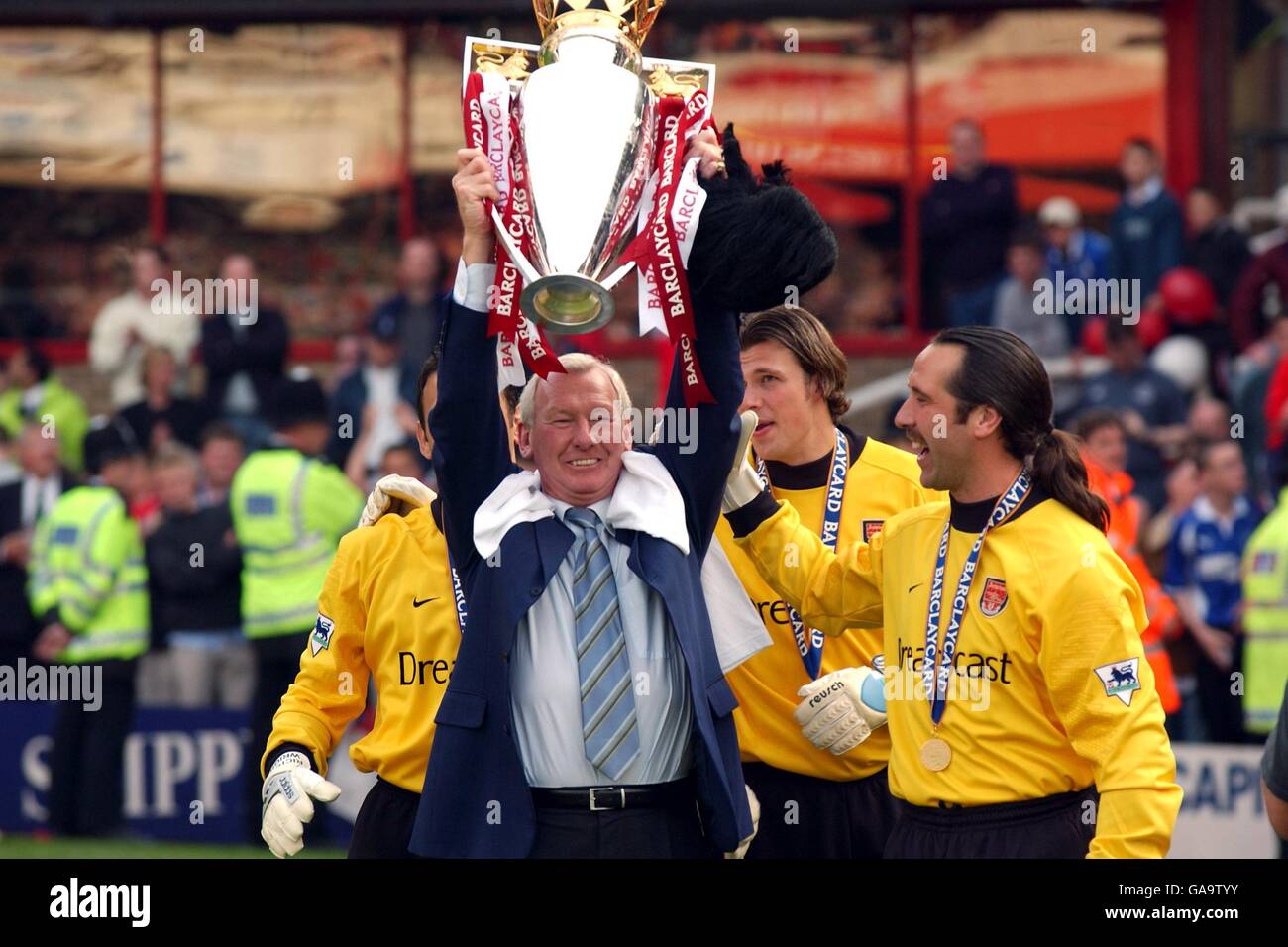 Arsenal's Goalkeeper Coach Bob Wilson holds aloft the FA Barclaycard Premiership trophy surrounded by the Arsenal goalkeepers Richard Wright, Stuart Taylor and David Seaman Stock Photo