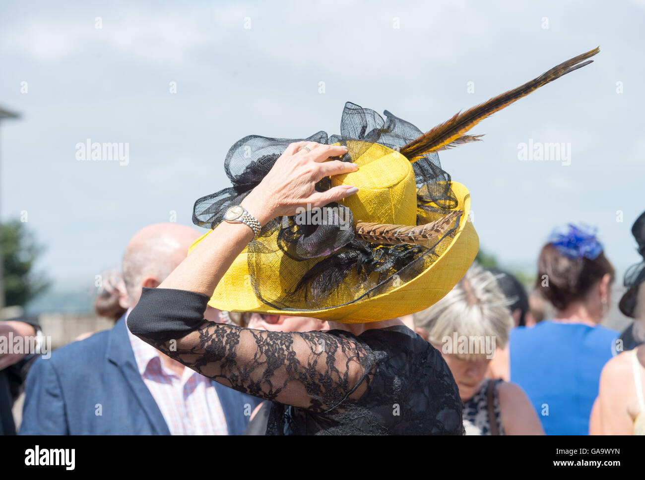 Brighton, Sussex, UK. 4th August 2016. Women have to hang on to their hats as they arrive for Brighton Races Ladies Day in beautiful sunny but windy weather conditions this afternoon . Ladies Day is the second day of the Brighton Racecourse three day August Festival of Racing  Credit:  Simon Dack/Alamy Live News Stock Photo