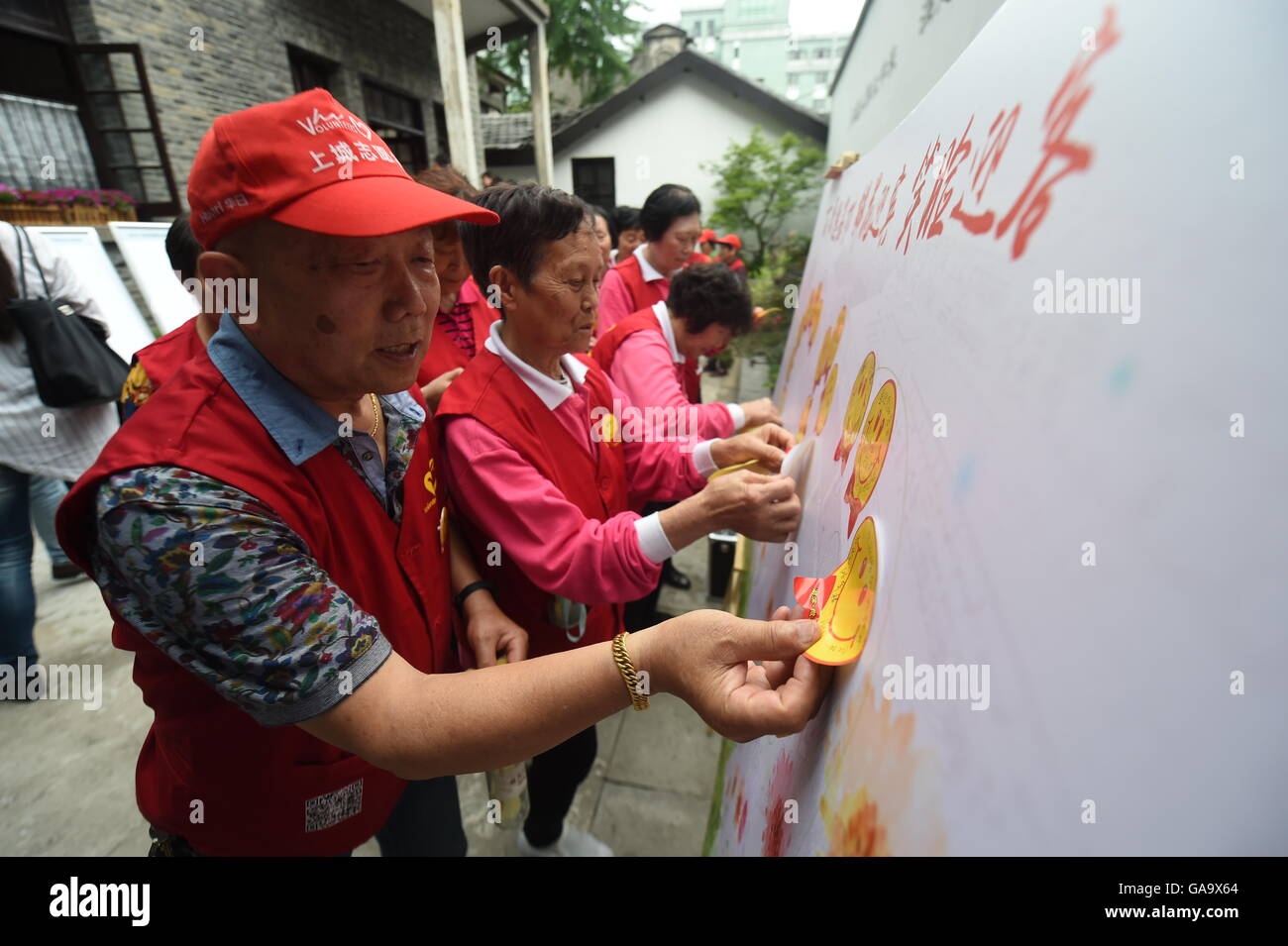 Hangzhou, China's Zhejiang Province. 25th May, 2016. Volunteers paste up stickers of smile on the wall in the Shangcheng District in Hangzhou, east China's Zhejiang Province, May 25, 2016. Hangzhou is the host city for the 2016 G20 summit on Sept. 4 and Sept. 5. With one month to go, Hangzhou looks forward to G20. © Wang Dingchang/Xinhua/Alamy Live News Stock Photo