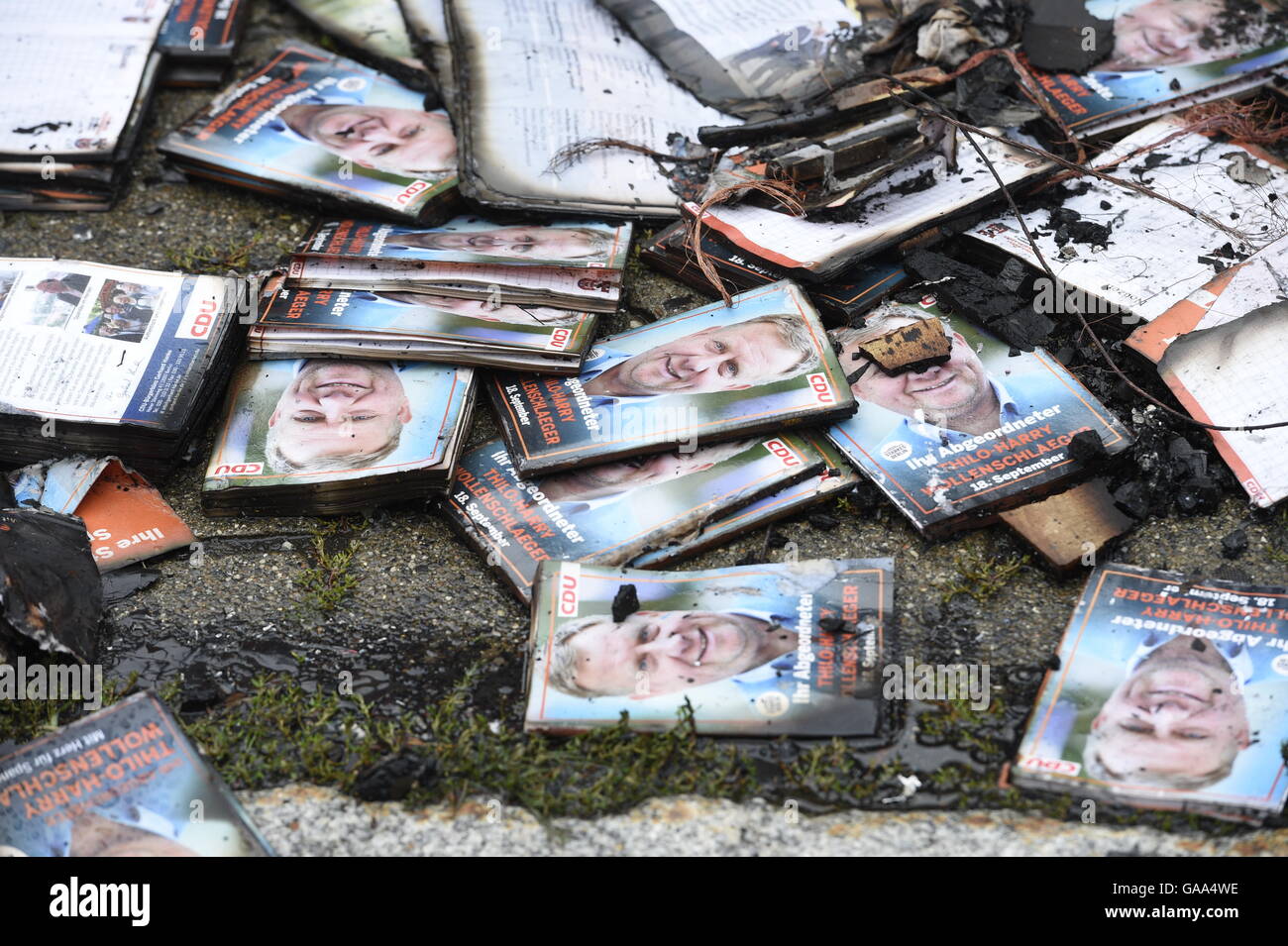 Berlin, Germany. 5th Aug, 2016. Leaflets of CDU politician Thilo-Harry Wollenschlaeger lying next to a burned-out election campaign bus in Berlin, Germany, 5 August 2016. The campaign bus was completely gutted by fire in Berlin-Staaken. The polizeilicher Staatsschutz (lit. police state security) is investigating. PHOTO: RAINER JENSEN/DPA/Alamy Live News Stock Photo