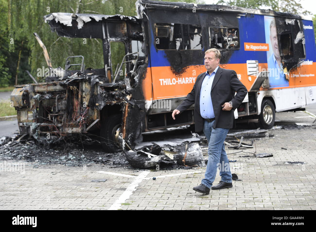 Berlin, Germany. 5th Aug, 2016. CDU politician Thilo-Harry Wollenschlaeger walking past his burned-out election campaign bus in Berlin, Germany, 5 August 2016. The campaign bus was completely gutted by fire in Berlin-Staaken. The polizeilicher Staatsschutz (lit. police state security) is investigating. PHOTO: RAINER JENSEN/DPA/Alamy Live News Stock Photo