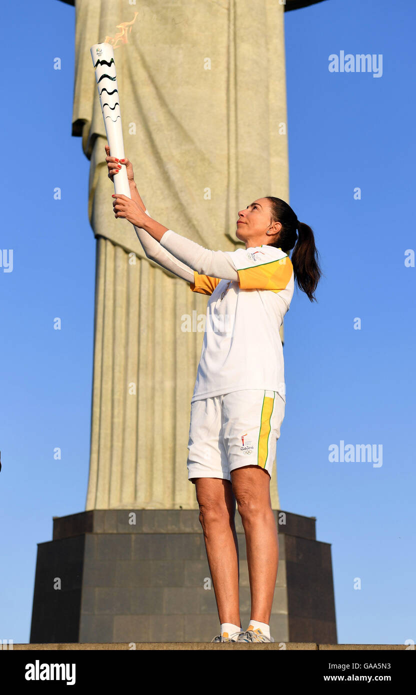 Rio de Janeiro, Brazil. 5th Aug, 2016. Brazilian former volleyball player Maria Isabel Barroso holds the Olympic torch during the Olympic Torch Relay in front of Christ the Redeemer statue early in the morning prior to the Rio 2016 Olympic Games in Rio de Janeiro, Brazil, 5 August 2016. Rio 2016 Olympic Games take place from 05 to 21 August. Photo: Sebastian Kahnert/dpa/Alamy Live News Stock Photo