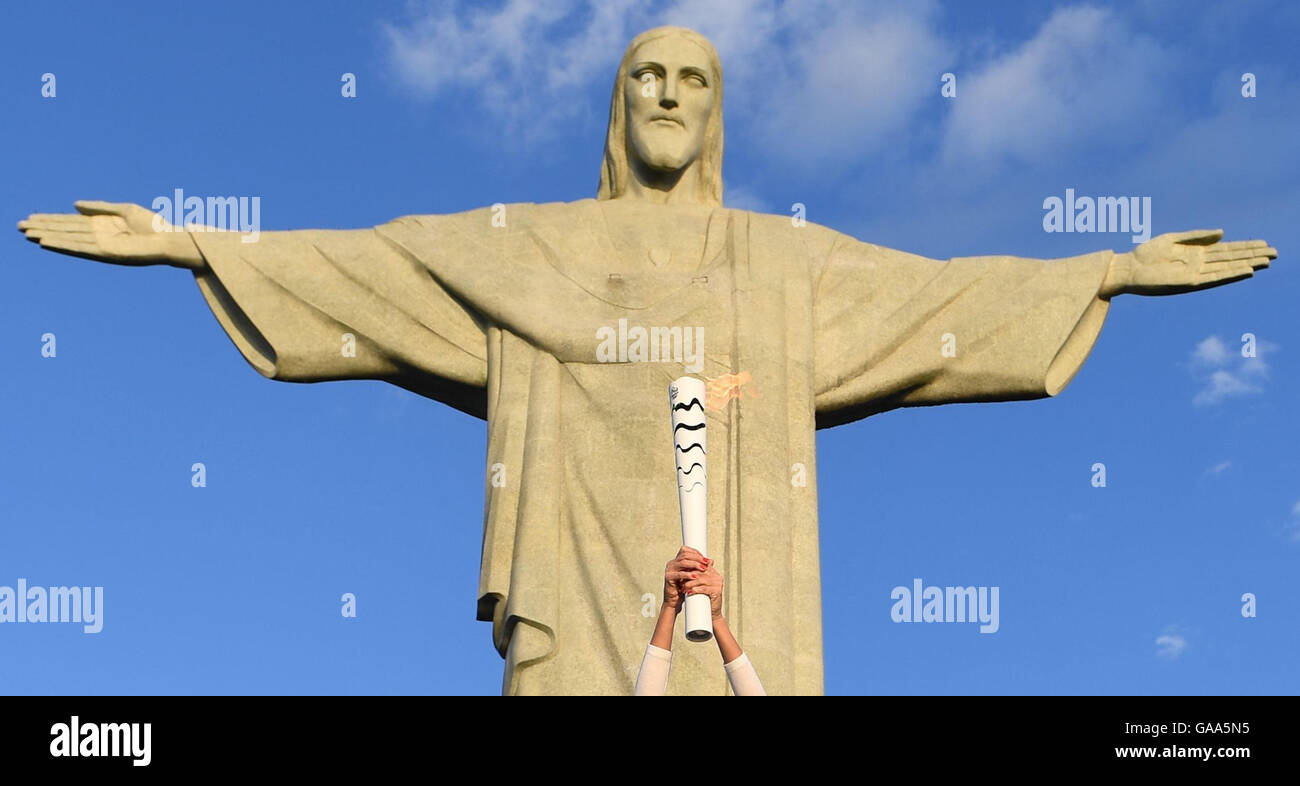 Rio de Janeiro, Brazil. 5th Aug, 2016. Brazilian former volleyball player Maria Isabel Barroso (not pictured) holds the Olympic torch during the Olympic Torch Relay in front of Christ the Redeemer statue early in the morning prior to the Rio 2016 Olympic Games in Rio de Janeiro, Brazil, 5 August 2016. Rio 2016 Olympic Games take place from 05 to 21 August. Photo: Sebastian Kahnert/dpa/Alamy Live News Stock Photo