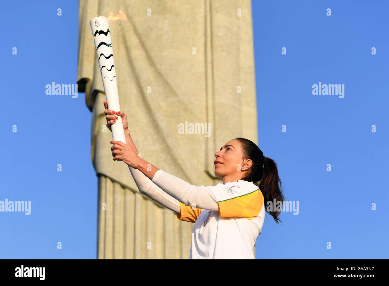 Rio de Janeiro, Brazil. 5th Aug, 2016. Brazilian former volleyball player Maria Isabel Barroso holds the Olympic torch during the Olympic Torch Relay in front of Christ the Redeemer statue early in the morning prior to the Rio 2016 Olympic Games in Rio de Janeiro, Brazil, 5 August 2016. Rio 2016 Olympic Games take place from 05 to 21 August. Photo: Sebastian Kahnert/dpa/Alamy Live News Stock Photo