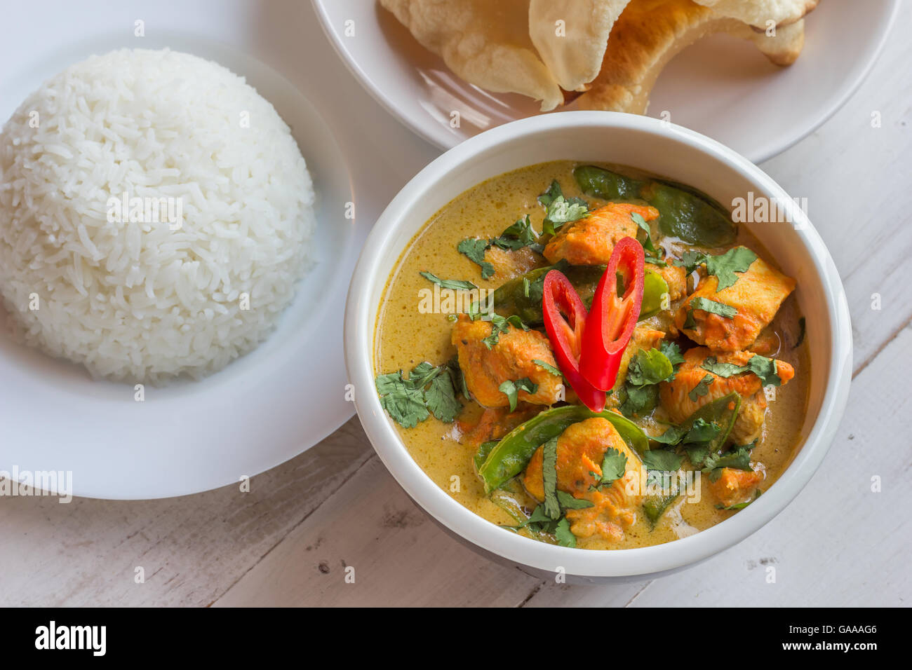 Indian green curry with chicken, basmati rice and papadums Stock Photo