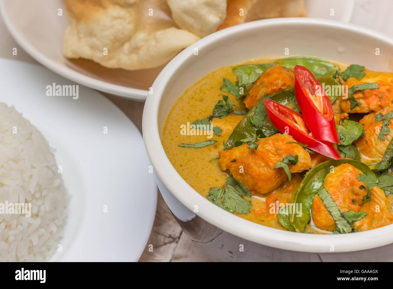 Indian green curry with chicken, basmati rice and papadums Stock Photo