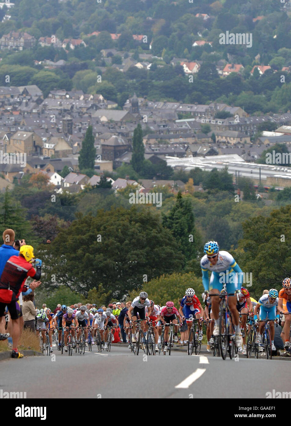 Riders in todays stage of the Tour of Britain Cycle Race start the long climb out of Ilkley passing the Cow and Calf rocks before the finish in Bradford during the Tour of Britain, England. Stock Photo