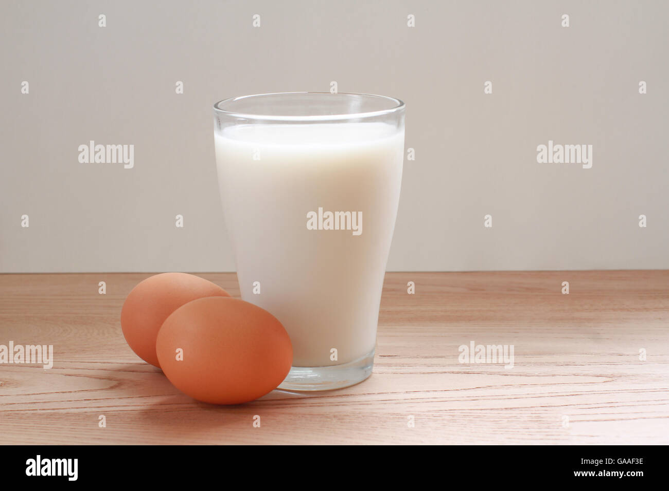 Glass of milk and two eggs on a table Stock Photo - Alamy