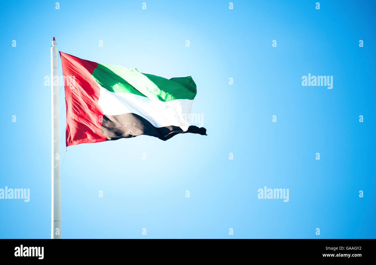 United Arab Emirates flag flying against clean and tranquil sky Stock Photo