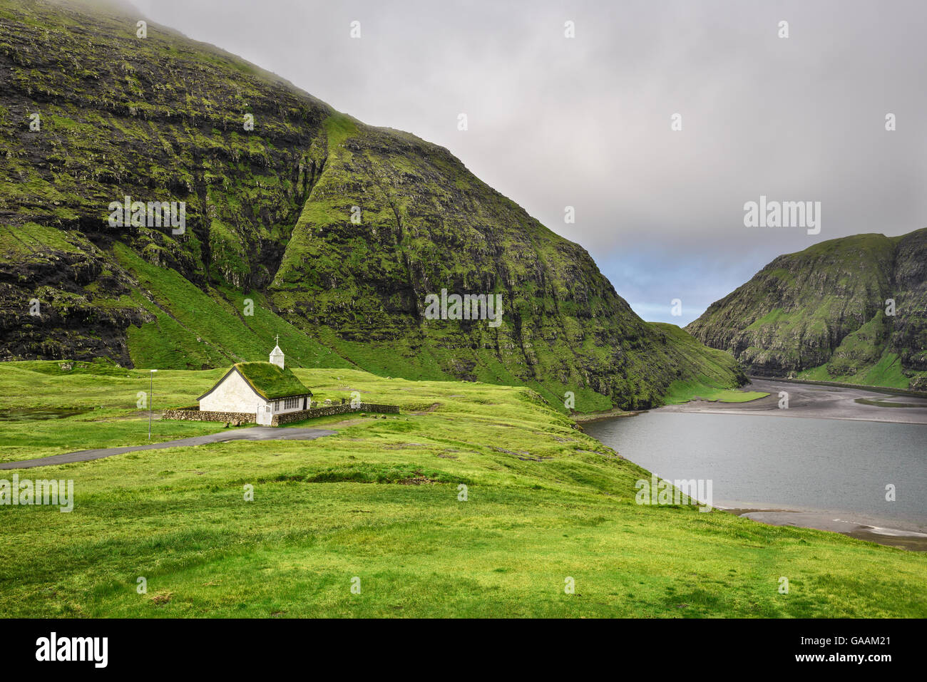 Small village church in Saksun and a nearby lake located on the island of Streymoy, Faroe Islands, Denmark Stock Photo