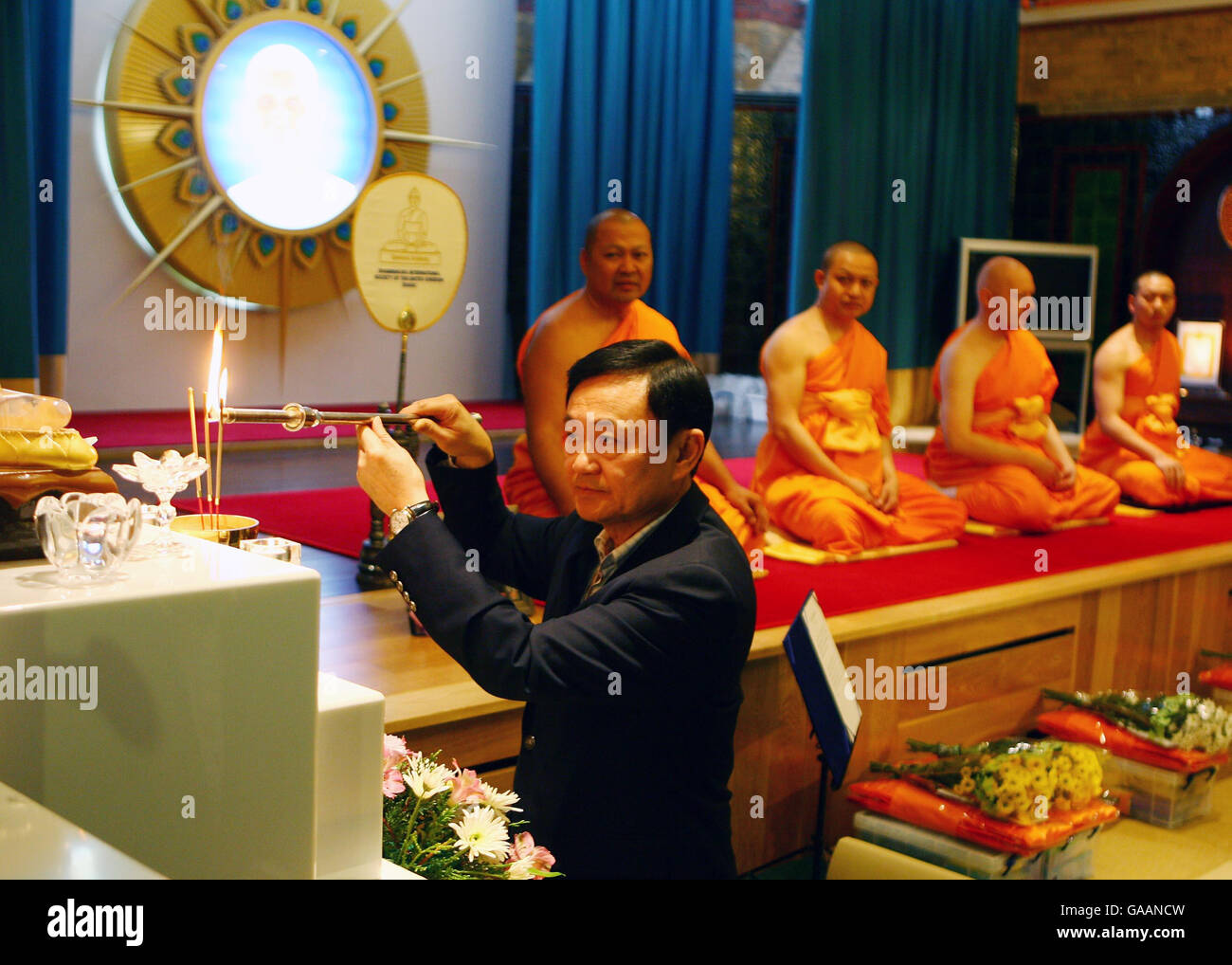 Dr. Thaksin Shinawatra, former Prime Minister of Thailand, marks his respect for Bhudda at the Dhammakaya Centre for Buddist Meditation in Knaphill, Surrey, a year after being ousted from office. Stock Photo